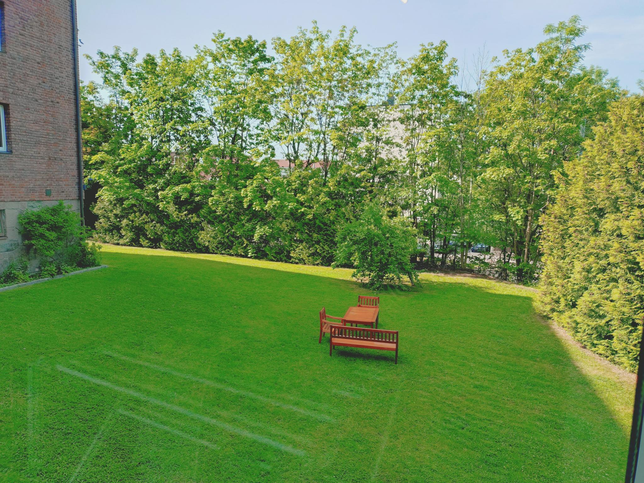 Utsikt fra vinduet. Fine grøntarealer rundt bygget som beboerne disponerer.